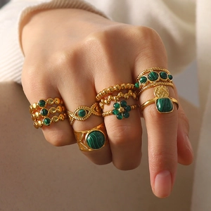 Close-up of 18K gold-plated rings set with natural green malachite stones on hand