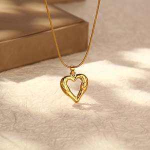 Gold stainless steel heart pendant necklace with irregular lava texture on snake chain
