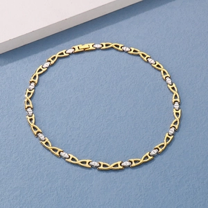 Detail view of two-tone chain necklace with folding clasp on textured blue background