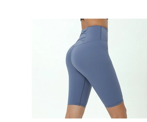 Detail view of high-waisted gray-blue yoga shorts featuring a cross-strap design on the back