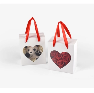 White rectangular gift box featuring heart-shaped window and red ribbon handles