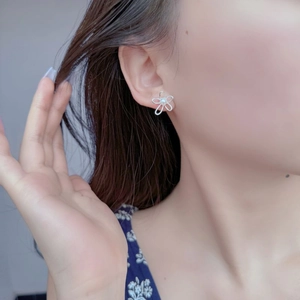 Close-up of 925 sterling silver flower earring with freshwater pearl on a model