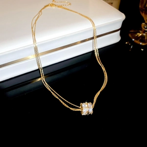 Detail of gold layered chain necklace with a sparkling pavé zircon cylinder pendant