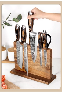 Macro view of chef knife being removed from a magnetic solid wood block holder