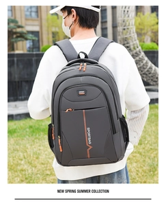 Detail of dark grey waterproof backpack with orange zippers and sport lettering