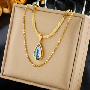 Detail of gold double-layer necklace featuring a rainbow crystal teardrop pendant