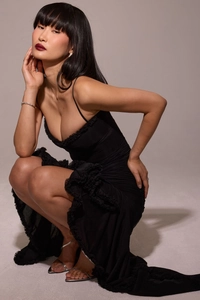 Detail shot of black slim-fit evening dress featuring elegant ruffled edges and textures