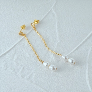 Detailed macro view of S925 silver long gold pearl drop earrings with crystal studs