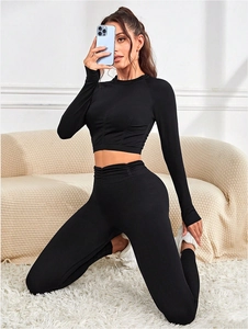 Détail d'ensemble de yoga noir en maille côtelée avec haut manches longues et legging