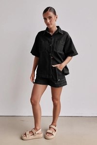 Detailaufnahme des vintage schwarzen Denim-Sets mit Utility-Hemd und Cargo-Shorts