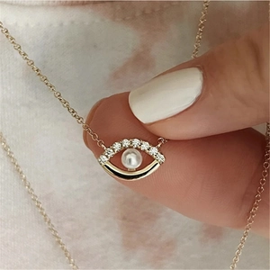 Close-up of gold 925 sterling silver angel eye necklace with pearl and sparkling zircons