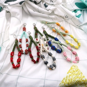 Detailed fan-shaped display of seven colorful hand-woven floral lanyards with silver clasps