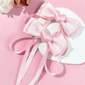 Pink satin bow hair clips with heart charms and long ribbons for sweet girls' hairstyles