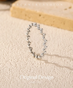 Detailed view of S925 sterling silver beaded ring on a textured beige background