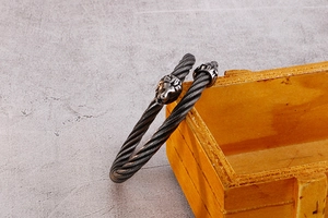 Gros plan du bracelet en câble d'acier torsadé avec têtes de lion de style vintage