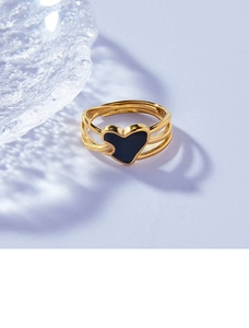 Détail d'une bague triple anneau dorée avec un cœur en émail noir élégant au centre