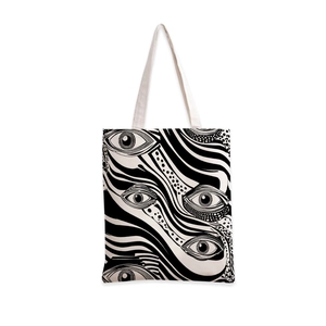 Détail d'un sac cabas en toile avec un motif d'œil abstrait noir et blanc contrasté