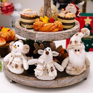 Three plush Christmas dolls featuring Santa, reindeer, and snowman on a wooden tray