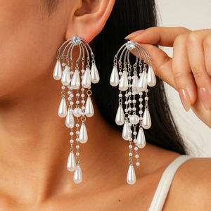 Silver fringe tassel earrings with white drop pearls and zircons on a model