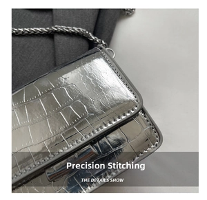 Close-up of metallic silver crocodile pattern leather and refined stitching on flap bag