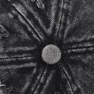 Top view detail of washed denim baseball cap with six-panel stitching and distressed accents