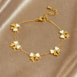 Elegant gold plated stainless steel bracelet featuring five white enamel bow charms on silk
