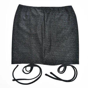 Detail view of the black sequin texture and side drawstring on the bodycon skirt