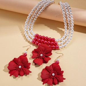 Three-layer faux pearl necklace with large red flower pendant and matching floral earrings
