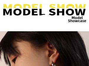 Close-up of silver C-shaped earrings with brushed texture on female model's ear