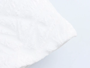 Detailed macro view of white dress fabric with 3D geometric jacquard texture