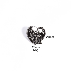 Detail view of heart-shaped skeleton embrace enamel pin with size and weight metrics