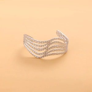 Macro shot of silver hollow wavy layered stainless steel bangle with woven texture