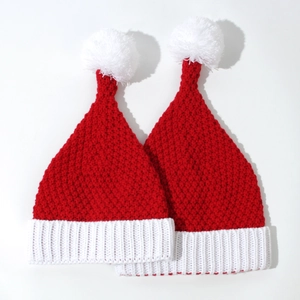 Close-up of thick knit Christmas hats with white pom poms and ribbed cuff details