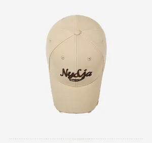 Top view of beige baseball cap with 1990 embroidery and distressed brim details