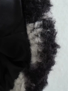 Close-up of black and white plaid plush fabric and smooth black lining of the coat