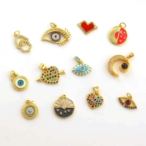 Flat lay of multiple 18K gold plated charms with zircons and evil eye designs