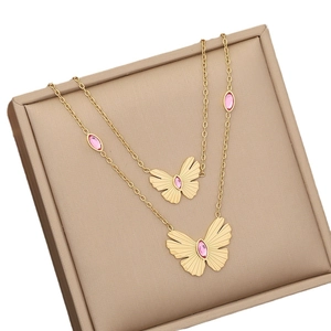 Double-layered gold necklace featuring pink oval gemstones and butterfly pendants