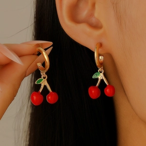 Sweet cherry earrings with red fruit and green leaves on gold rings worn on ear