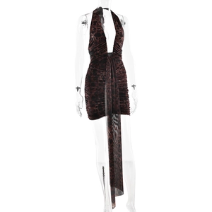 Detail of leopard print halter dress featuring a deep V-neck and asymmetric flowing hem