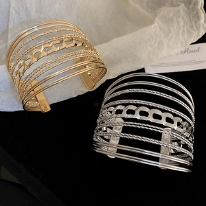 Detailed macro view of gold and silver multi-layer hollow geometric open cuff bracelets