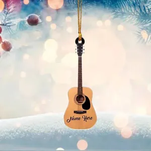 Custom guitar ornament with Name Here text hanging on festive tree with snowy background