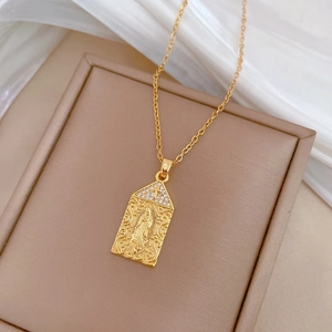 Macro view of gold-plated portrait pendant with zircon cross on silk background