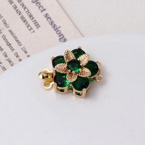 Dettaglio macro di una chiusura a fiore vintage con pietre verdi e metallo dorato