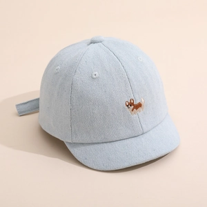 Détail montrant le tissu en jean et la broderie Corgi sur la casquette bébé