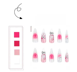 Detail of pink gradient stiletto nails with 3D silver bows and rhinestone heart accents