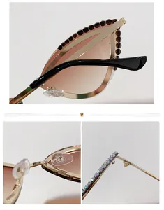 Detail of cat eye sunglasses with gold metal frame, rhinestones and gradient lenses