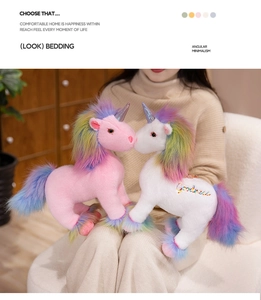 Detailed view of plush pink and white unicorns with soft faux fur and metallic horn texture