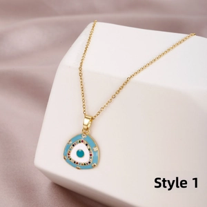 Detailed macro view of gold evil eye triangle pendant with micro-set zircon on white stand
