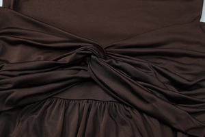 Close-up detail of smooth brown pleated fabric with an elegant waist twist knot design