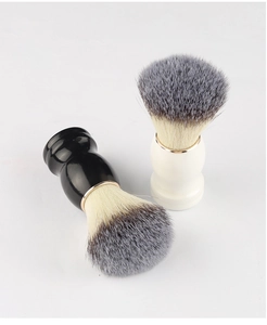 Detailopname van scheerkwasten met zachte haren en handvatten in zwart en crème op wit decor